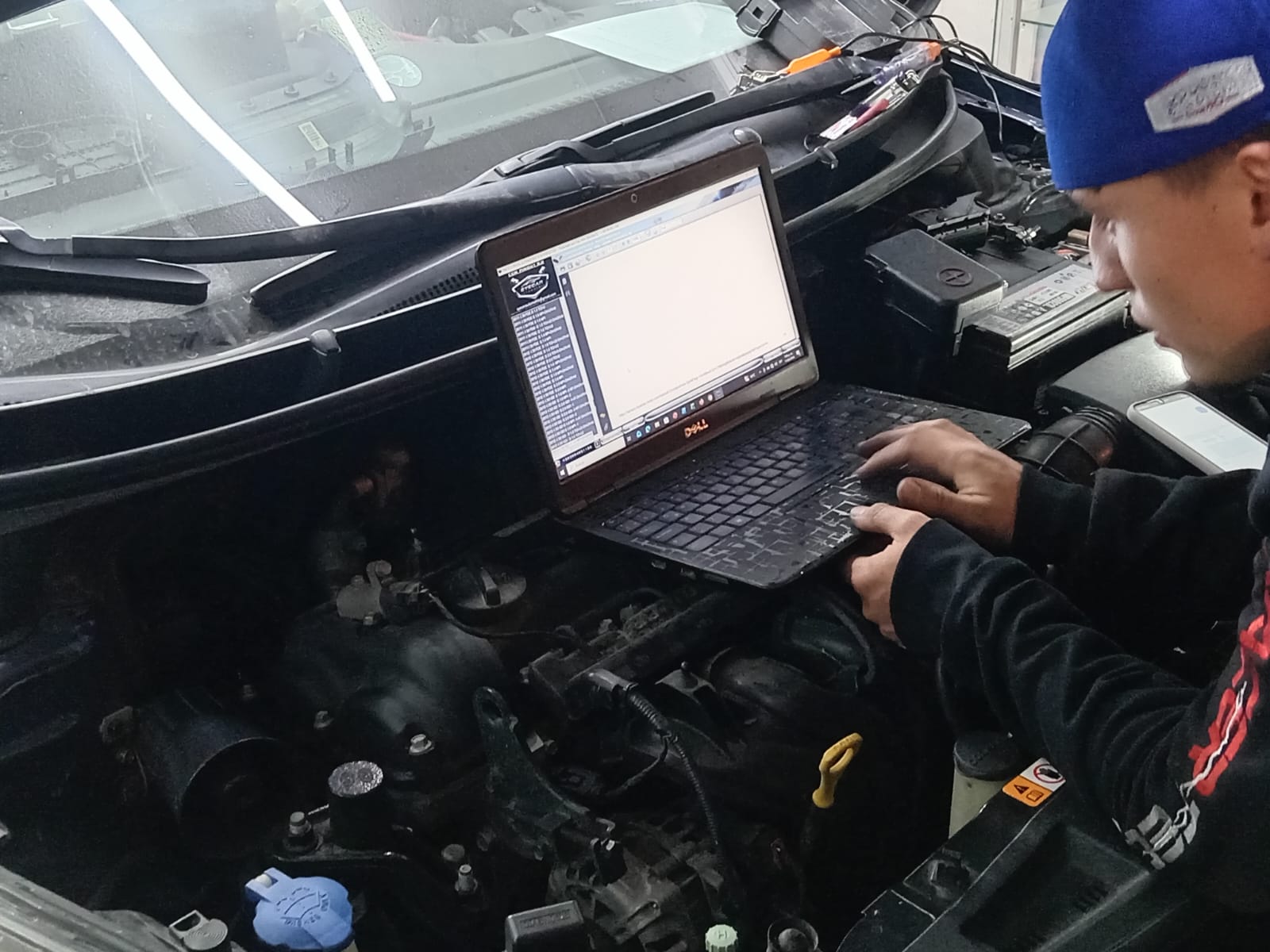Técnico automotriz realizando revisión electrónica